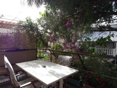 - Balcón con mesa blanca y sillas en izmir Tatil Evi Beach Resort Seferihisar, en Ürkmez