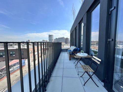 a balcony with a table and a view of a city at Large One Bedroom - Massive Private Terrace - Luxury Building - Williamsburg - Greenpoint in Brooklyn