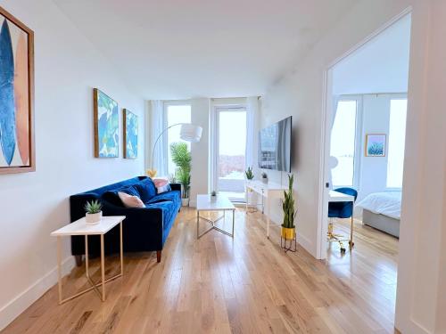 a living room with a blue couch and a table at Large One Bedroom - Massive Private Terrace - Luxury Building - Williamsburg - Greenpoint in Brooklyn