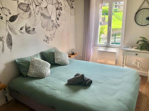 een slaapkamer met een groen bed met twee knuffels erop bij VerOliv : Superbe appartement rénové proche du centre-ville in Le Creusot