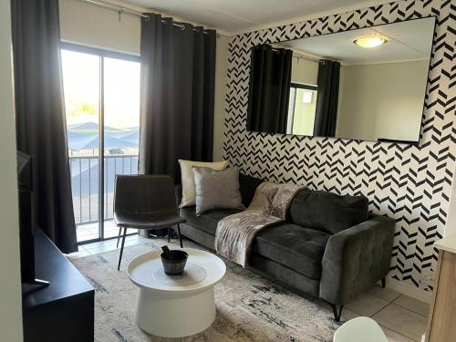 a living room with a couch and a mirror at The Lagoon Exquisite Apartments in Pretoria
