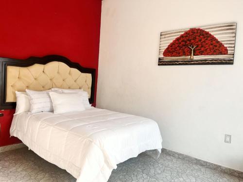a bedroom with a bed and a painting of a fruit at Hotel Peña Florencia in Bernal