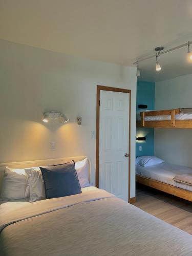 a bedroom with a bed and two bunk beds at Auberge Internationale de Rivière-du-Loup O76381 in Rivière-du-Loup