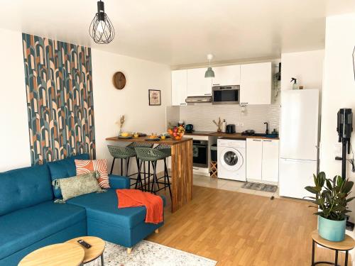 un salon avec un canapé bleu et une cuisine dans l'établissement Le Refuge Urbain, à Villejuif