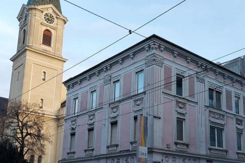 a building with a clock tower in front of a building at Appartement Top 4 - Premium in Linz