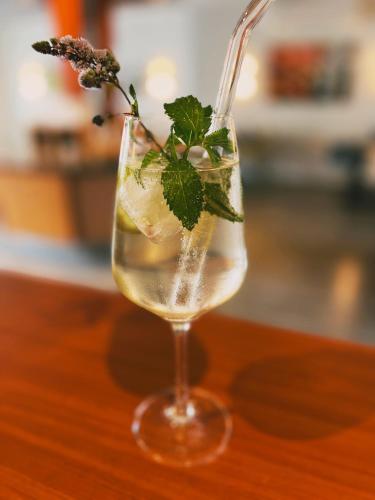 a glass of water with a plant in it on a table at Moselhotel Weinhaus Simon `Sauna`Restaurant`ELadesäule in Wintrich