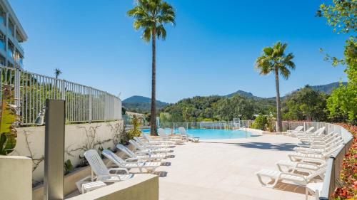 une rangée de chaises longues à côté d'une piscine dans l'établissement Appartement au Riviera Golf Domaine de Barbossi, à Mandelieu-la-Napoule