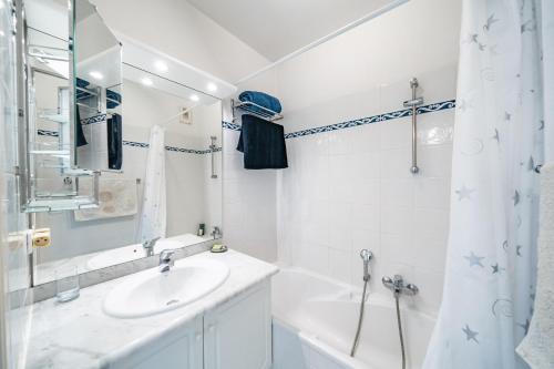 une salle de bain blanche avec un lavabo et une douche dans l'établissement Appartement au Riviera Golf Domaine de Barbossi, à Mandelieu-la-Napoule