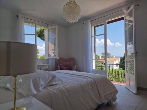 une chambre blanche avec un lit et une grande fenêtre dans l'établissement VILLA 4 Étoiles, MOANA , mer à 50 m ,été du Samedi au Samedi, à Saint-Peïre-sur-Mer