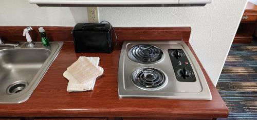 a kitchen counter with a sink and a stove at All Towne Suites in Saint Robert