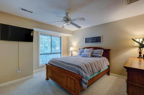 Un dormitorio con una cama con ventilador de techo y una ventana. en Updated luxury two bedroom The Greens Condo New Baths walk in shower Nice Kitchen Golf Views, en Hilton Head Island