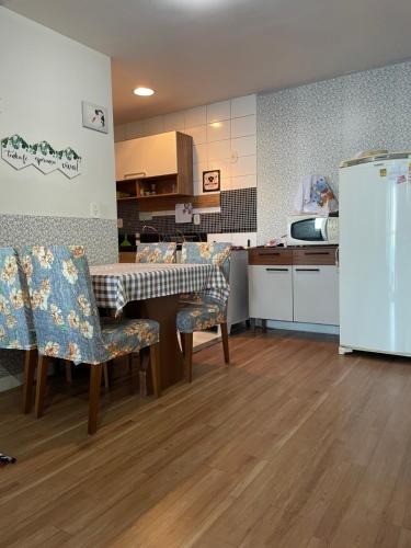a kitchen with a table and chairs and a refrigerator at FLAT frente Mar Green Diamond in Vila Velha