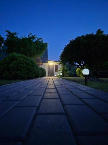 a stone walkway in front of a house at night at Namas Zarasuose su vyno rūsiu in Zarasai