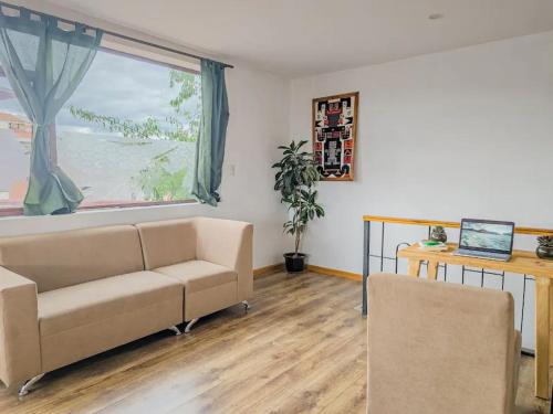 un soggiorno con un divano e una grande finestra di Hotel Chasky Cuenca a Cuenca