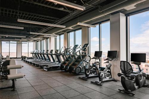 a gym with rows of tread machines and windows at Sonder at North Loop Green in Minneapolis