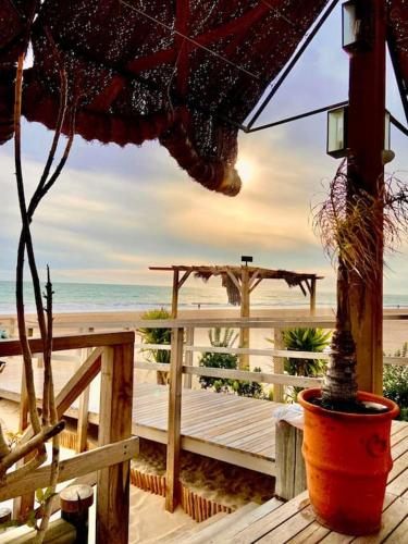 a wooden deck with an umbrella on the beach at Viento Grande, Apartamento boutique en la playa in Rota