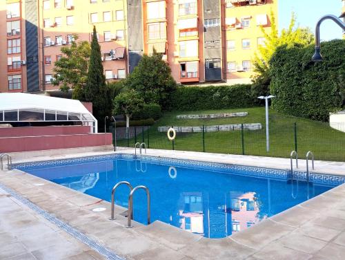 a large blue swimming pool with buildings in the background at Fridda House Atocha Madrid in Madrid