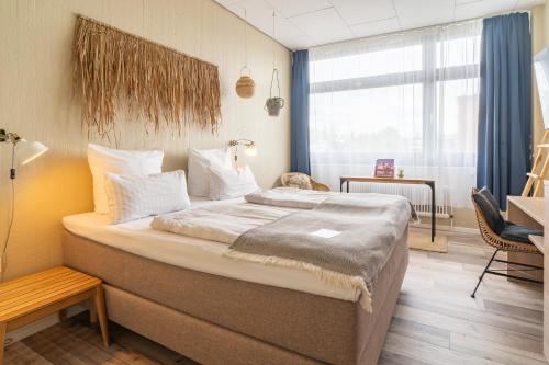 sypialnia z dużym łóżkiem i oknem w obiekcie Aqua Hotel w Konstancji
