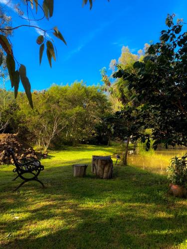 a park with a bench and a tree stump at "Suite Cabaña Cantodeagua - Jacuzzi -Refugio en Reserva Natural Urbana - Villa de Leyva" in Villa de Leyva