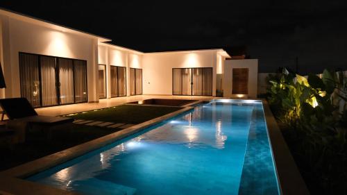 a swimming pool in the middle of a house at night at Villa YAOUH à Seseh in Munggu