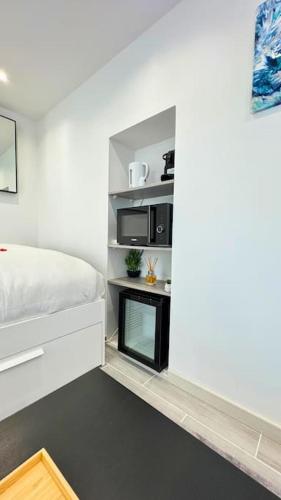 - une petite chambre avec un lit et un four micro-ondes dans l'établissement La suite EverBlue, à Saintry-sur-Seine