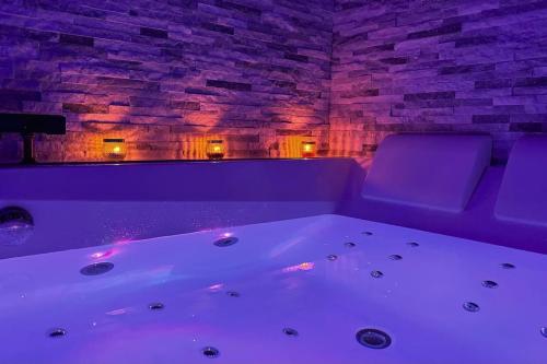 Cette chambre dispose d'une baignoire et d'un mur en briques. dans l'établissement La suite EverBlue, à Saintry-sur-Seine