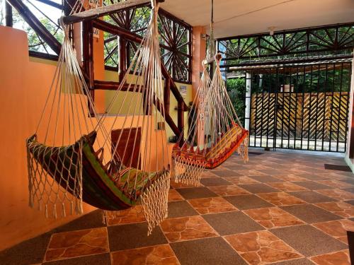 three hammocks hanging in a room with a stone floor at Hostal Casa Taisha in Montañita
