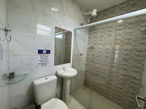 a bathroom with a toilet and a glass shower at Linda Casa com piscina Brisa do Mar - Maragogi in Maragogi