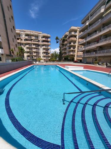 a large swimming pool with two buildings in the background at Beautiful apartment with swimming-pool in Salou