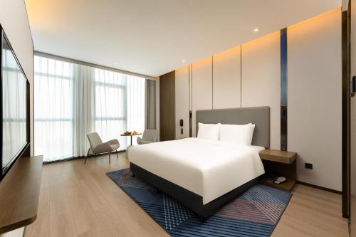 a bedroom with a large white bed and a desk at Holiday Inn Express Suzhou Bay by IHG in Suzhou