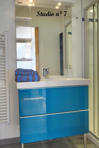 une salle de bain avec un lavabo bleu et un miroir dans l'établissement StudioLille - Rue d'Anvers, à Lille