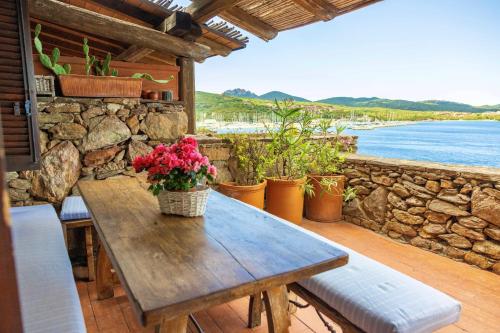 a wooden table on a patio with a view of the water at Sea View Apartment in Porto Rotondo