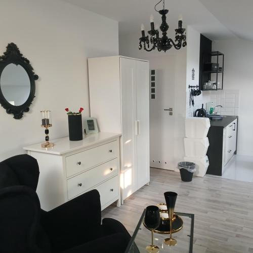 a living room with a chair and a mirror at Willa La mer-Balia z jacuzzi, sauna ,klimatyzacja ,rowery in Ustka