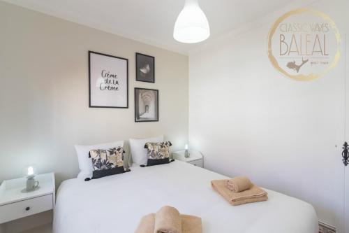 a white bedroom with a large white bed with pillows at Baleal Classic Waves Guest House in Baleal