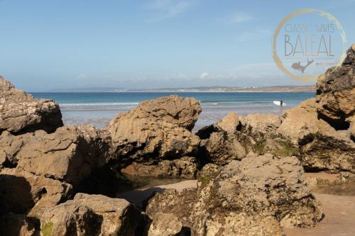 a beach with rocks and the words just us bahla at Baleal Classic Waves Guest House in Baleal