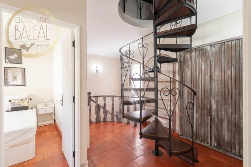 a spiral staircase in a living room with a stair case at Baleal Classic Waves Guest House in Baleal