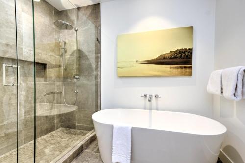 uma casa de banho com uma banheira e um chuveiro em vidro. em Predator Ridge Resort em Vernon