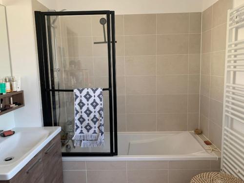 une salle de bain avec une baignoire et un lavabo dans l'établissement Maison des mésanges, à Colmar