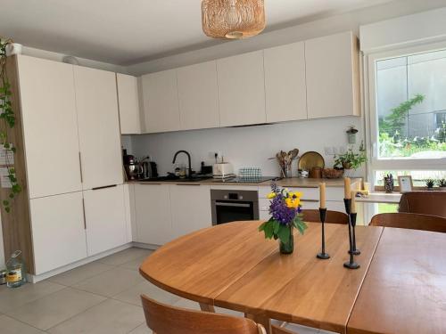 une cuisine avec une table en bois et des fleurs. dans l'établissement Maison des mésanges, à Colmar