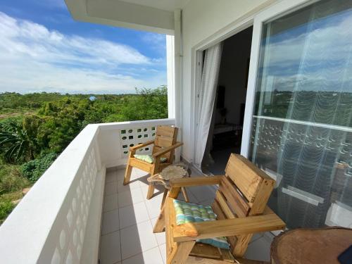 a balcony with two chairs and a view of the ocean at WissaHomeZanzibar in Dambani