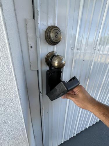 a person unlocking a door with a cell phone at Adrien Guest Studio in Miami Gardens
