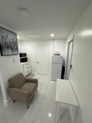 a living room with a chair and a refrigerator at Adrien Guest Studio in Miami Gardens