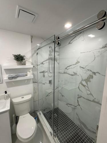 a bathroom with a toilet and a glass shower at Adrien Guest Studio in Miami Gardens