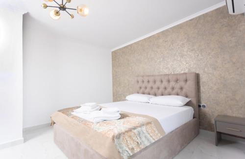 a white bedroom with a bed with white pillows at Victory VIP apartments in Kallithea Halkidikis