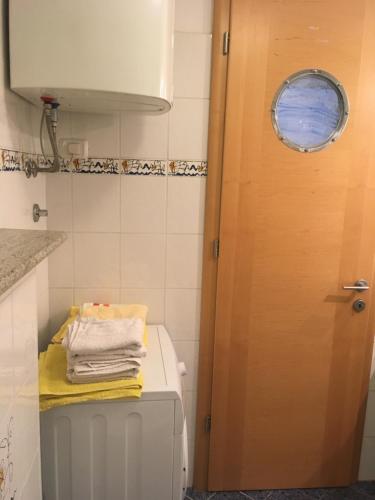 baño con aseo y puerta de madera en Apartment Ferrari, en Portorož