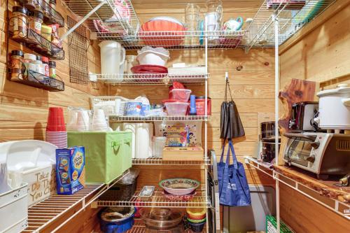 a kitchen with lots of food and dishes on shelves at Riverfront Cabin with Outdoor Oasis in Seminary! in Collins