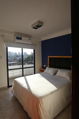 a bedroom with a large white bed with a large window at Cipres 4 B in San Miguel de Tucumán