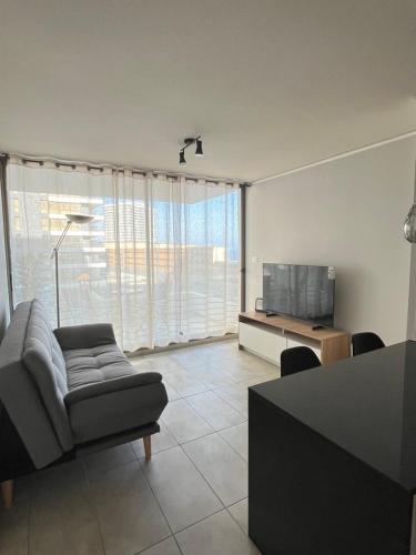 een woonkamer met een bank en een televisie bij Edif Roble in Antofagasta