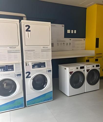two washing machines and a washer and dryer in a room at Boutique Bueno / Apto de luxo in Goiânia
