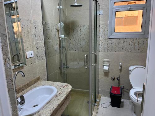 a bathroom with a shower and a sink and a toilet at Monte cairo Pool View in Cairo